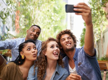 Arkadaşlık anlarını yakalıyor. Bir grup arkadaş fotoğraf makinesinde kendi portresini çekiyor.