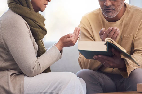 Worship, prayer and Muslim couple with a quran, reading and studying spiritual faith in their house. Religion, gratitude and holy and Islamic man and woman with a bible during Ramadan praying.