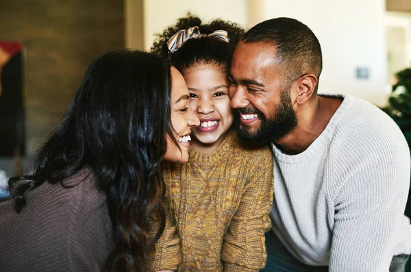 Black family, love and happiness portrait with a mother, father and child together with a smile, support and hug for gratitude. Man, woman and girl daughter bonding in the lounge while happy at home.