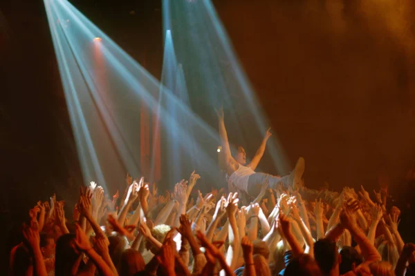 My fans carry me. A stage diver being carried across the audience at a rock concert