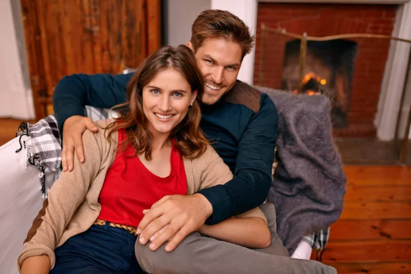 暖炉のそばでカールアップ 暖炉のそばのソファでリラックスしている若いカップル — ストック写真