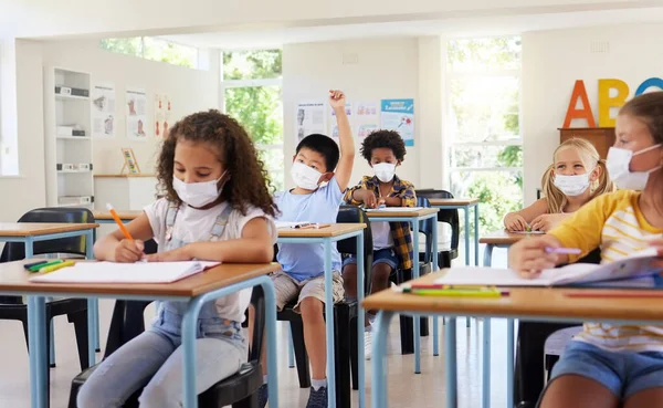 얼굴을 보호하는 마스크를 세계적 유행병이 교실에서 배우는 아이들이 있습니다 학교에 — 스톡 사진