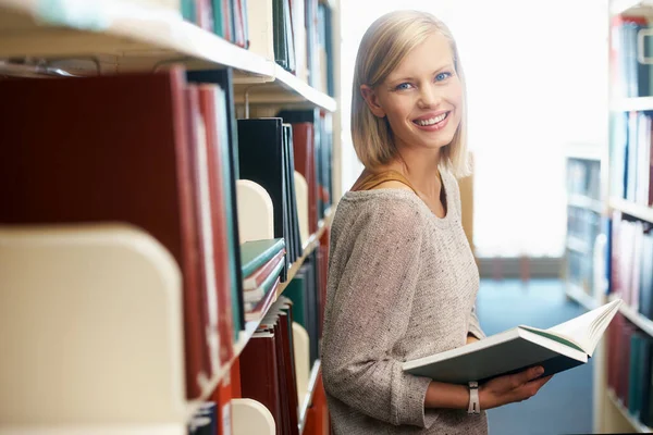 勉強用の資料を集めて 図書館に本を持っている若い女性 — ストック写真