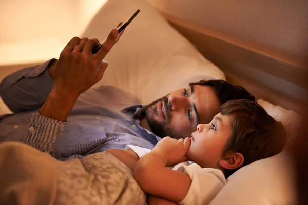 Modern bedtime story. A father reading a bedtime story to his son from an e-reader