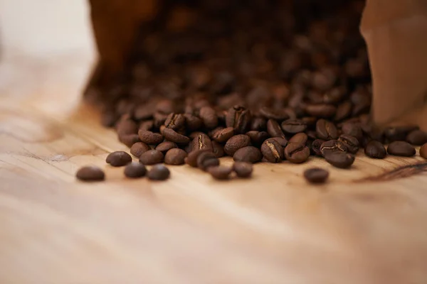 新鲜咖啡的乐趣 烤咖啡豆从柜台上的袋子里漏出来 — 图库照片