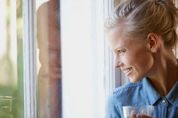 在家里度过轻松的一天 一位年轻女子站在窗边喝茶 — 图库照片