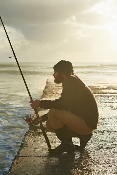海にはたくさんの魚がいる 桟橋で釣りをしている若い男 — ストック写真