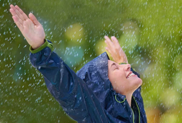 雨の中で踊る 雨を楽しむレインコートを着た若い女性が — ストック写真