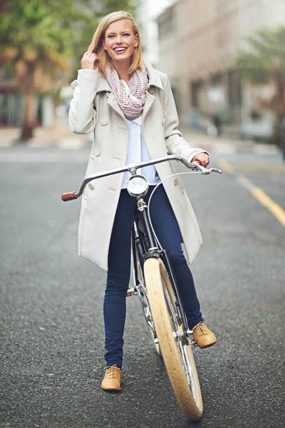 I enjoy cycling through the city. Full length portrait of an attractive young woman standing with her bicycle in the city