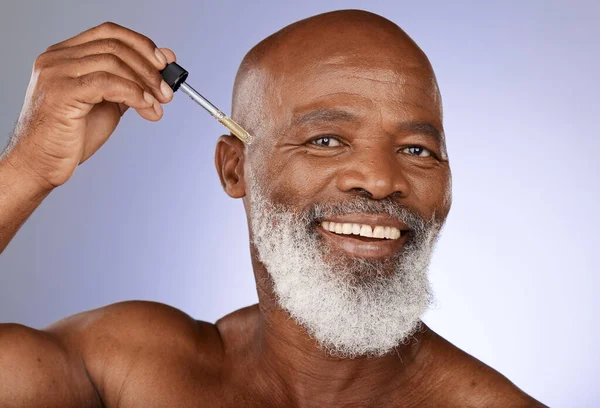 stock image Skincare, oil and portrait of senior man in studio for healthy skin, wellness and facial grooming. Dermatology, spa and elderly black man with serum, skincare products and liquid for face treatment.