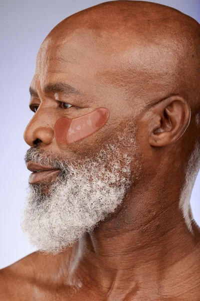 Face of senior model with collagen patch for facial hydration, anti aging routine or self care treatment. Skincare, spa salon and beauty profile of black man with hyaluronic acid under eye patches.