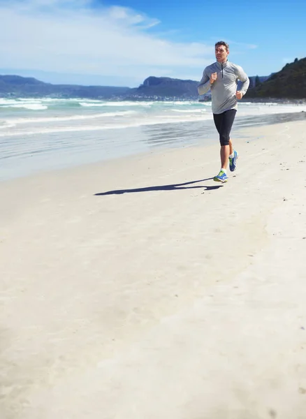 フィットネスマニア ビーチに沿ってジョギングする男の完全な長さのショット — ストック写真