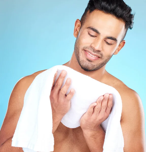 Cleaning, towel and face of man clean after wellness wash, facial cleaning routine and skincare mockup. Happiness, smile and person after bath or shower for body self car on blue studio background.