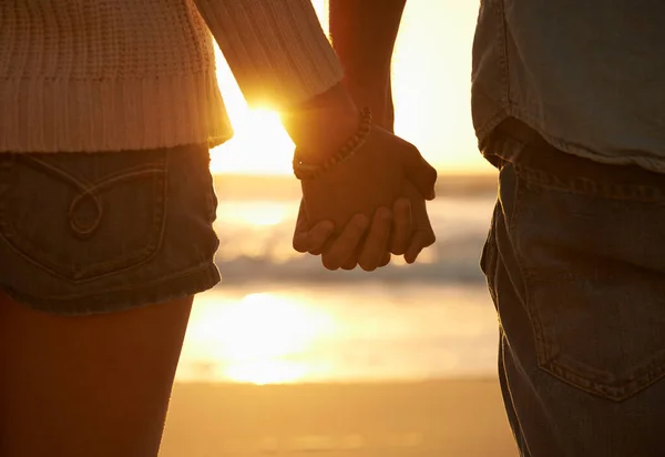 stock image Sunset on the shore. Cropped image of a couple standing hand in hand on the beach at sunset