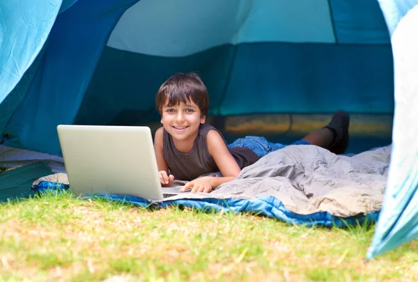 数码娱乐在户外的伟大 一个小男孩躺在帐篷里用笔记本电脑 — 图库照片