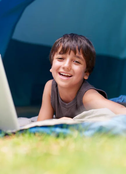 数码娱乐在户外的伟大 一个小男孩躺在帐篷里用笔记本电脑 — 图库照片