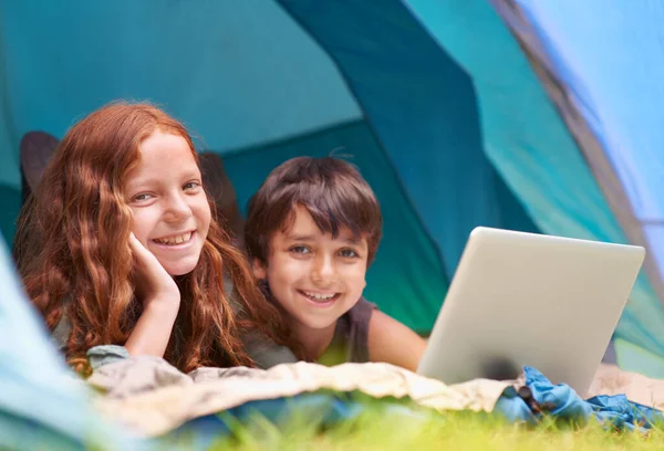 从荒野进入网络 一个弟弟和妹妹外出露营时在网上冲浪 — 图库照片