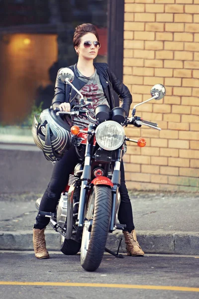 她把那辆自行车弄得好看极了 外面一位年轻貌美的女摩托车骑手 — 图库照片