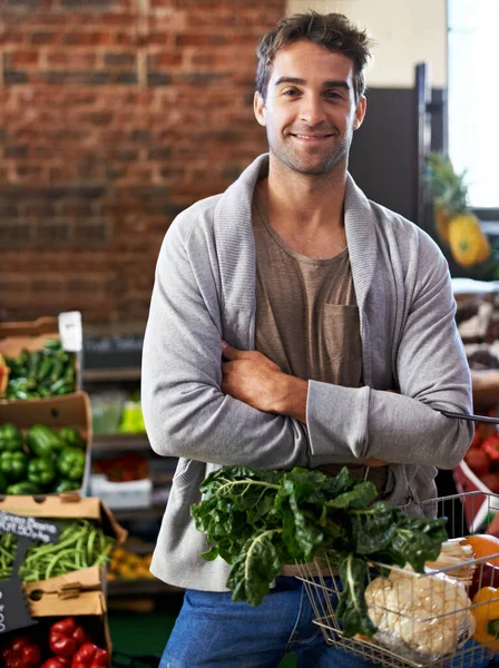 私はいつも健康的な選択をします 新鮮な食材でいっぱいのバスケットを持っている食料品店の若い男の肖像画 — ストック写真