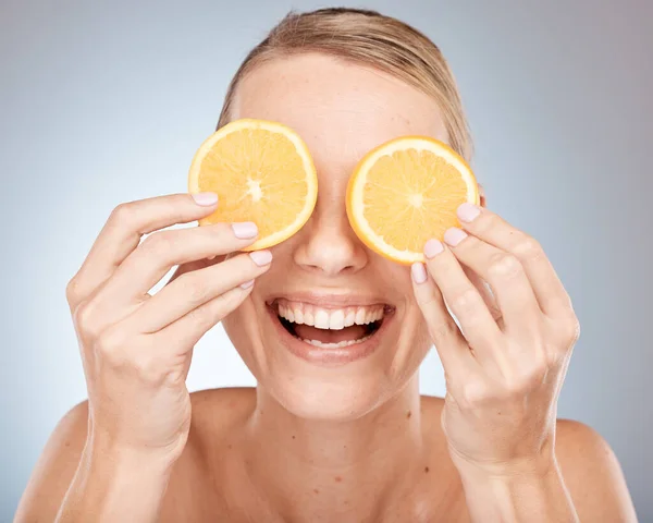 Lemon, eyes and skincare woman in studio for cosmetics, makeup and health of nutrition benefits and results promotion. Happy model with fruits for vitamin c on skin care, dermatology and facial.