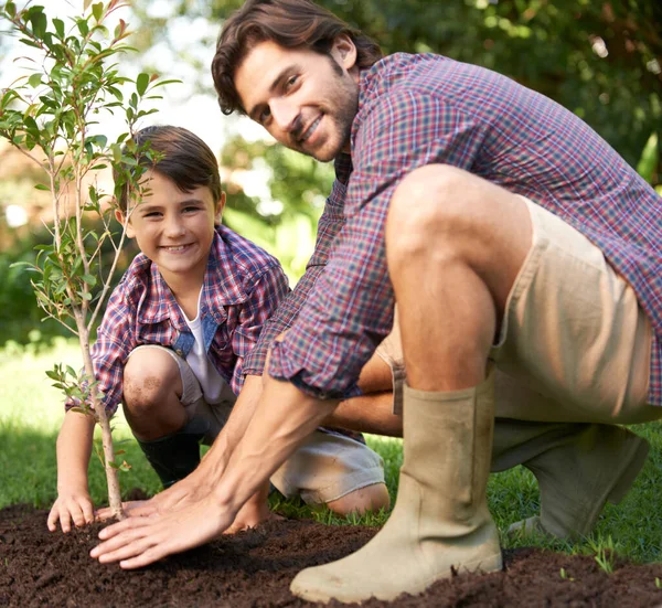お父さんと木を植える 小さな男の子と父親が庭に木を植え — ストック写真