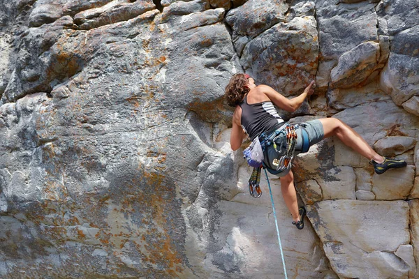 岩の顔を拡大して 山に登る女がハーネスで固定されてる — ストック写真