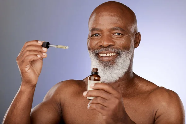 Portrait, skincare and black man with oil serum cosmetics for acne, wrinkles or anti aging protection in studio. Face, senior or old man marketing an essential oil bottle or natural luxury product.