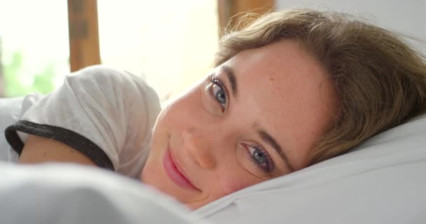 给快乐的女人画像 早上好 在俄罗斯舒服柔软的枕头上放松一下 年轻女性睡后躺在床上 健康地休息或小睡以求得健康 安宁和安宁的脸 — 图库视频影像
