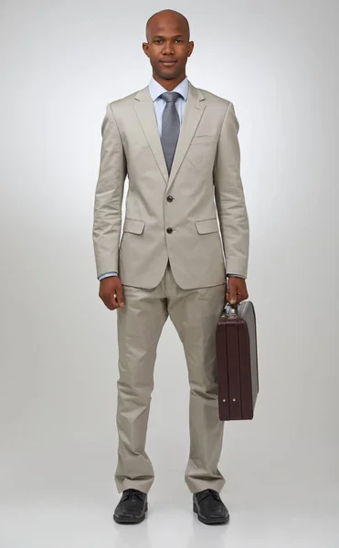 stock image Office on the run. Studio portrait of an african american businessman holding a briefcase