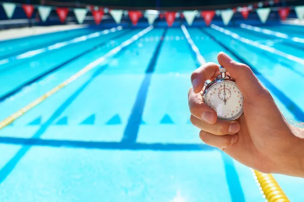 时间考验 把秒表放在游泳池前的一只手 — 图库照片