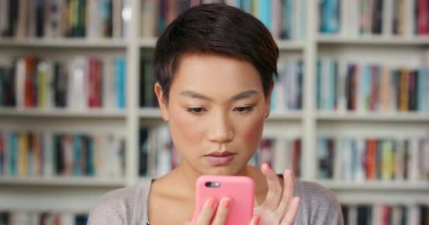 Bibliotheek Telefoon Blij Aziatisch Student Sms Typen Scrollen Social Media — Stockvideo