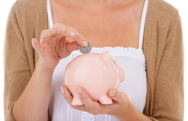Financial stability gives peace of mind. A young woman putting a coin into her piggybank