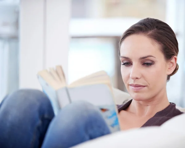 不要根据一本书的封面来判断它 一个女人躺在沙发上看书 — 图库照片