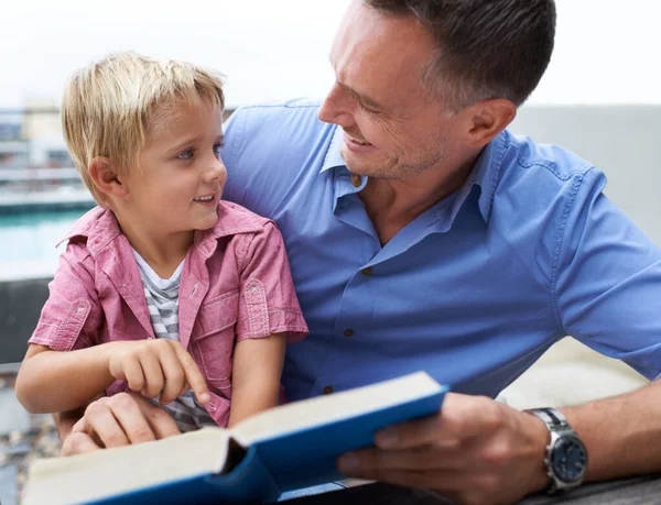 I love it when dad reads to me. a father reading to his little boy