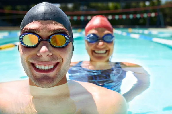 准备去游泳 一个男人和一个女人站在游泳池里 戴着护目镜和泳帽 — 图库照片