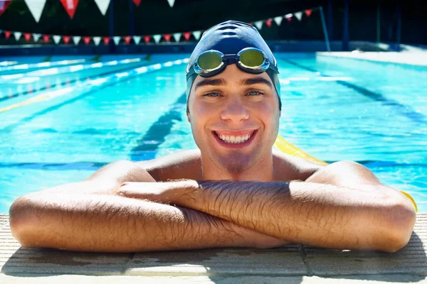 这是锻炼身体的最好方法 英俊的男子游泳运动员在游泳池边休息时微笑着 — 图库照片