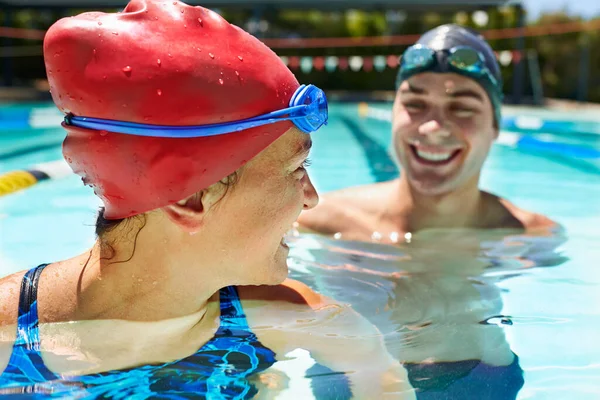 友好的竞争 两个游泳的人站在游泳池里 对着每个人微笑 — 图库照片