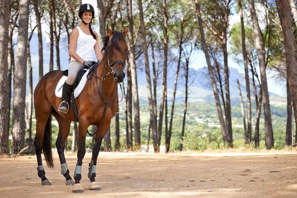 彼女にトレイルをうまく走るようにしている 栗の馬の上に座っている若い女性 — ストック写真