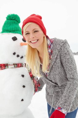 Portre, kış ve bir kadınla bir kardan adam Noel 'de, dışarıda İngiltere' de kar altında. Yüzü, yüzü ve yüzü kardan adam ile xmas ya da şenlik sezonu bir gülümsemeyle kutlamak ve eğlenmek için.