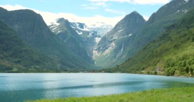 Göl, su ya da nehirli doğa, manzara ve kar dağı mavi gökyüzü ve yeşil çimlerle yolculuk için. Norveç 'te kış, buz ve tatil yeri sakin, zen ve barış için açık hava.