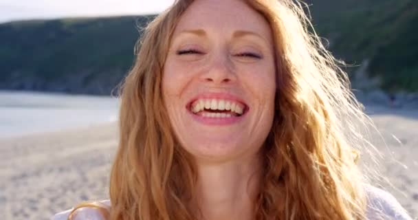微笑着 面对来自爱尔兰的女人 开心地在海边笑着 在大自然中度过夏天的旅行 假日休息 一个人在阳光下平静地刻画自己 享受自由的生活 — 图库视频影像