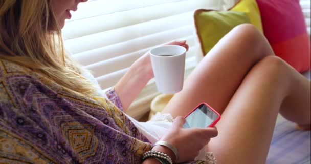 リラックス 女性は部屋でコーヒーを飲む テキストメッセージ ソーシャルメディアとチャット カップと画面 ベッドルームでの女性とオンラインチャット 彼女の家のウェブとインターネット検索 メッセージやアプリを読む — ストック動画