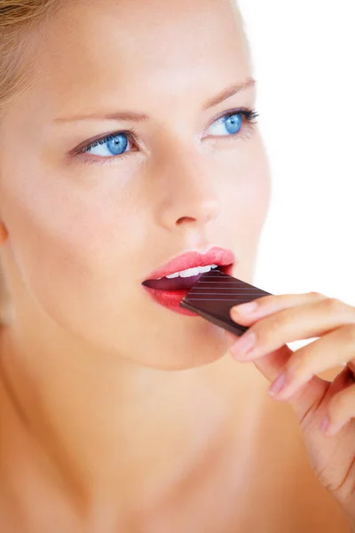 Chocolate is filled with antioxidants. Beautiful young woman enjoying a delicious piece of chocolate