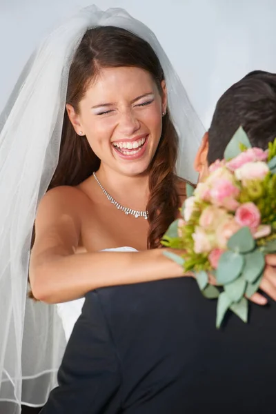 在他们的大日子里玩得开心极了 一个年轻的新娘牵着一束鲜花拥抱她的丈夫 — 图库照片