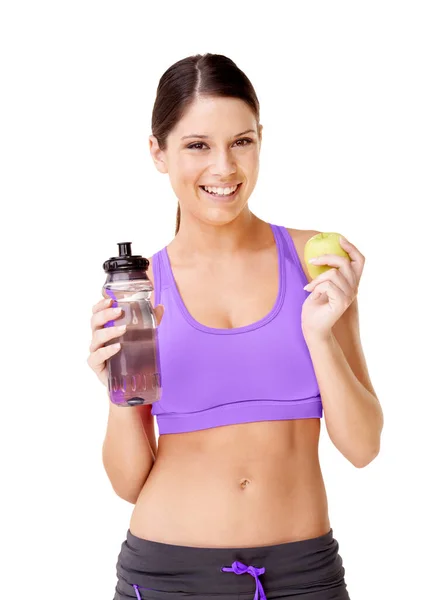 合理饮食和保持健康 一个穿着运动服的年轻女子 手里拿着一个苹果和一个用白色隔开的水瓶 — 图库照片