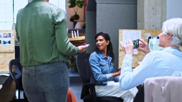 给员工打电话或者生日快乐 还有蛋糕惊喜 还有员工在社交媒体上录音 聚会或兴奋的员工在办公室桌上微笑着 并得到了同事或同事们的掌声 — 图库视频影像