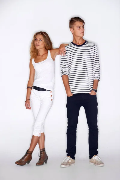 Hipster fashion. Hipster male and female standing in a studio and both looking the other way
