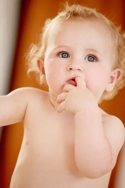 我想知道是什么在那里 可爱的男婴站在室内吸吮手指 — 图库照片