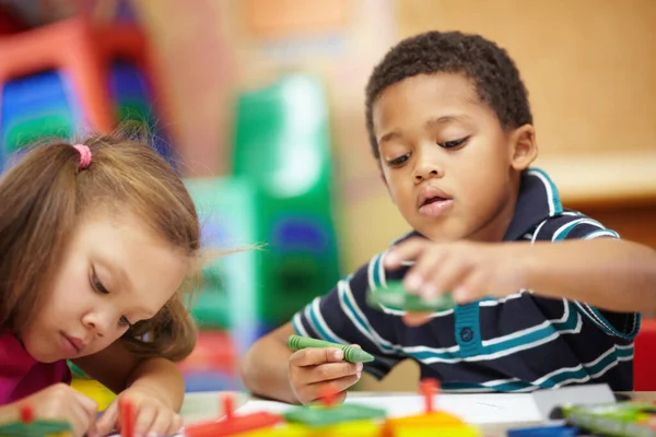 学习和发展 学龄前族裔男孩和女孩在学前教育教室里用彩色蜡笔画 — 图库照片