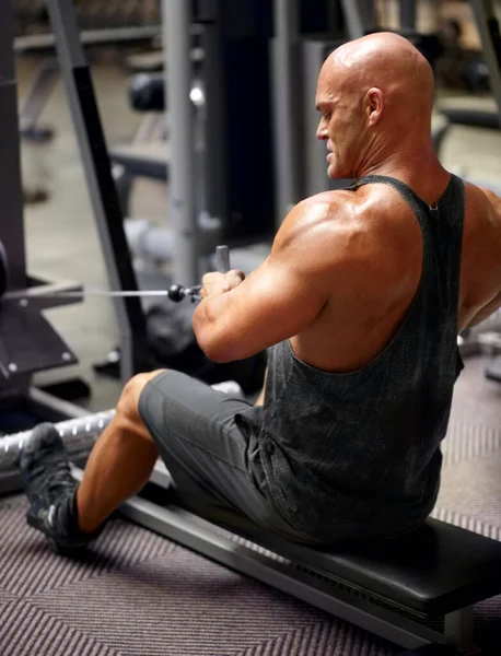 锻炼他膨胀的肌肉 一名男性健美运动员在体育馆里使用运动器械拍摄的后视镜 — 图库照片